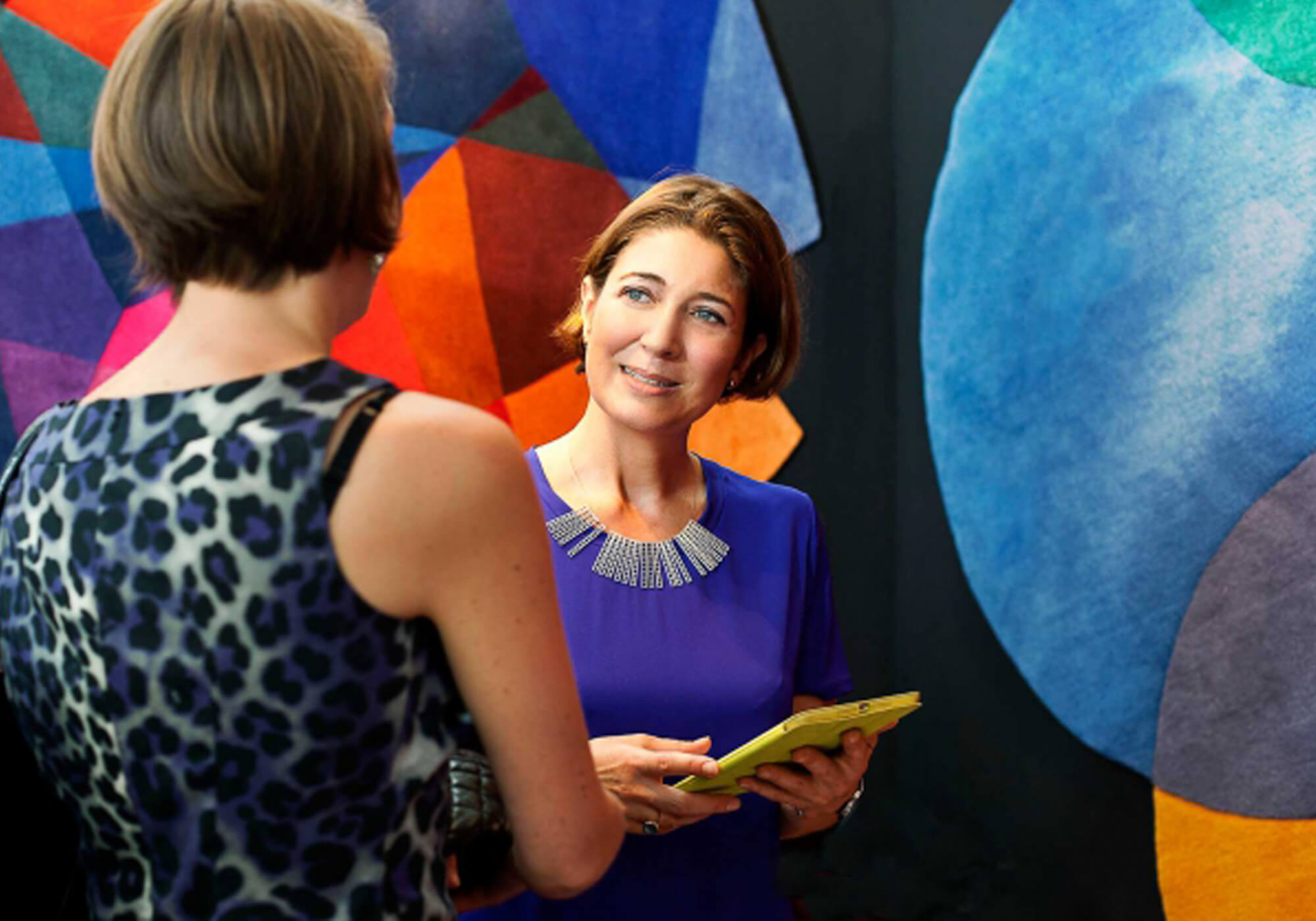 Portrait of contemporary rug designer Sonya Winner in front of her iconic, geometric After Matisse and Bubbles rug