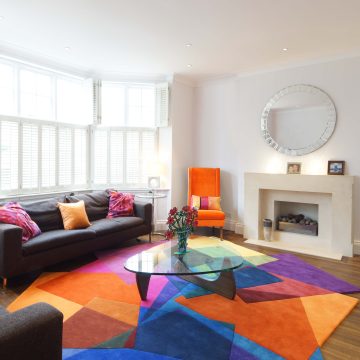 Sonya Winner After Matisse rug shown in a modern living room with Noguchi coffee table, B&B Italia black sofa and colourful graphic cushions