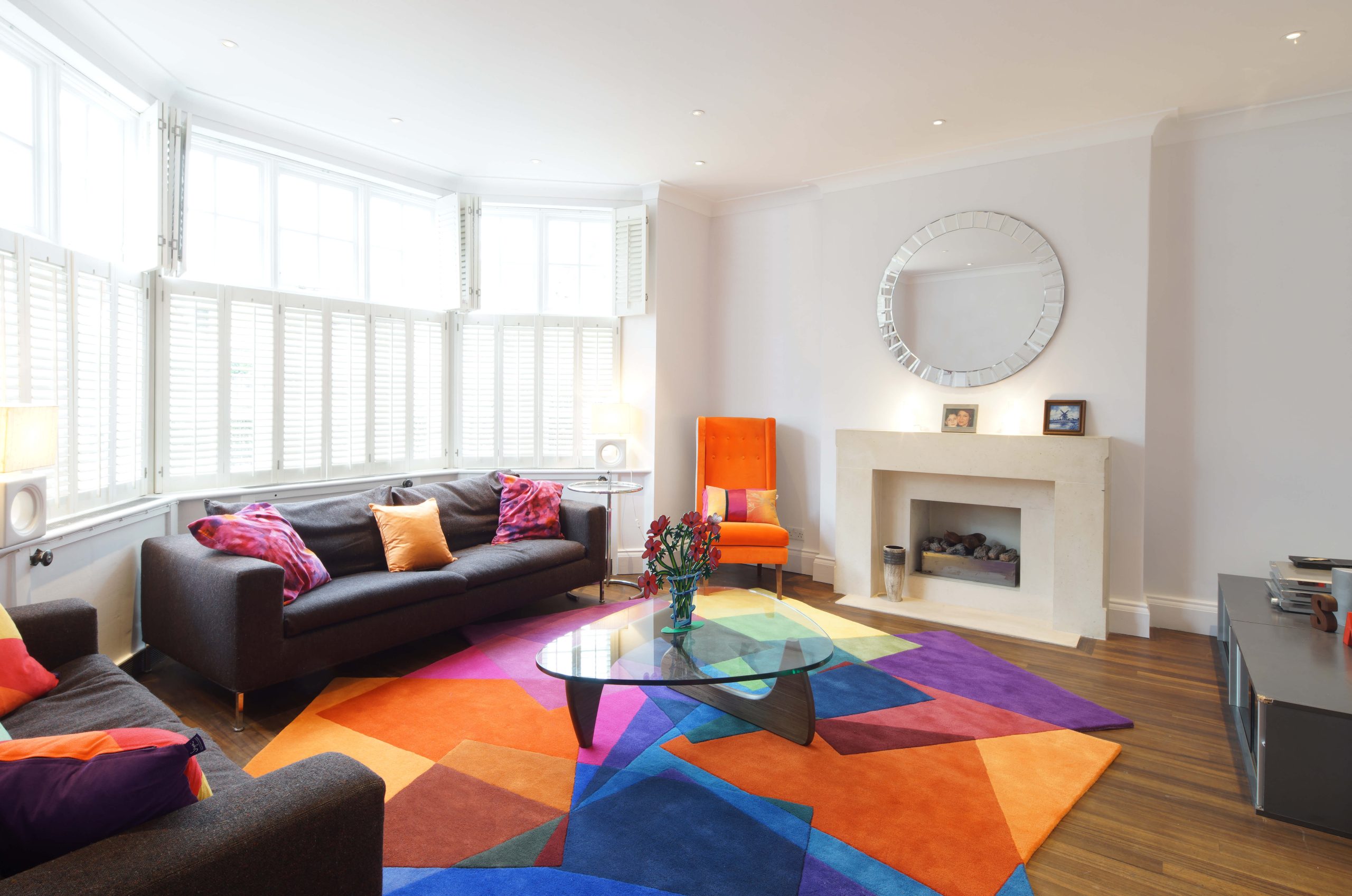 Sonya Winner After Matisse rug shown in a modern living room with Noguchi coffee table, B&B Italia black sofa and colourful graphic cushions