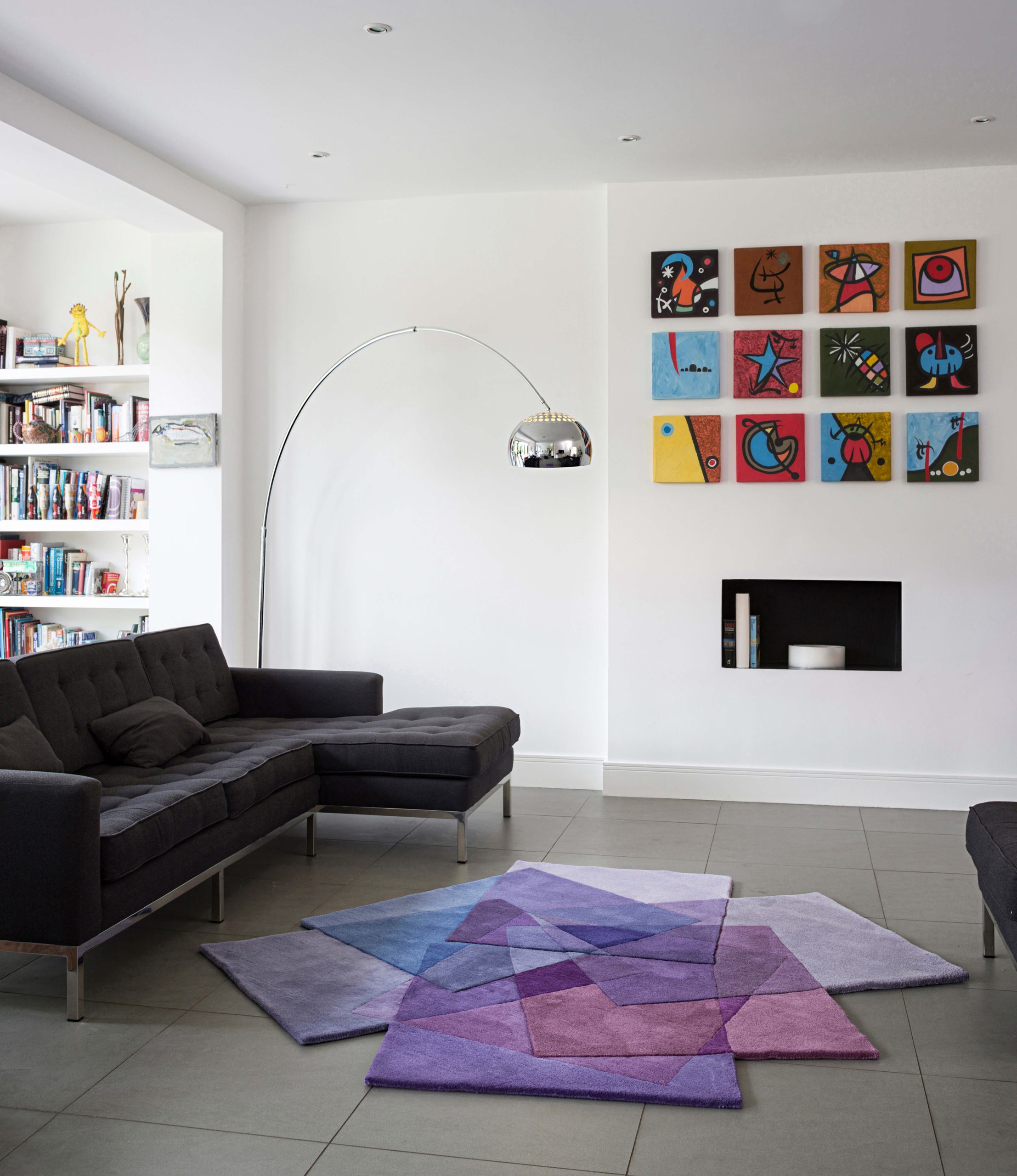 Sonya Winner After Matisse Purple rug shown in a modern living room with B&B Italia black sofa, Arco floor lamp by Achille Castiglioni and colourful abstract wall prints