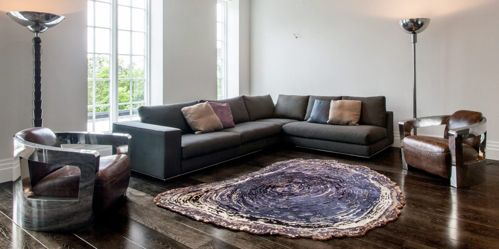 Sonya Winner nature inspired Tree Trunk silk rug shown in a classic lounge setting with black sofa