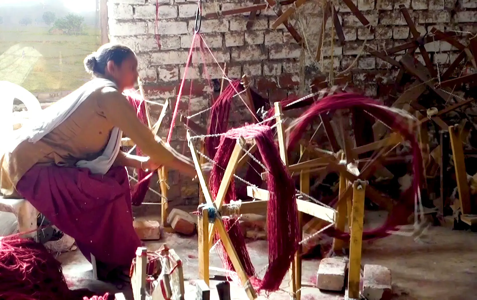Female weaver spinning red yarn