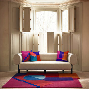 Set of 3 cushions Geometric designer pink, red and blue Santorini Sunset cushion on sofa