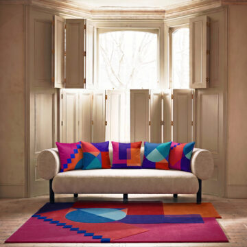 Set of 5 cushions Geometric designer pink, red and blue Santorini Sunset cushion on sofa